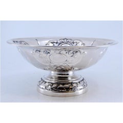 Silver candy box with reliefs, round base and floral motifs