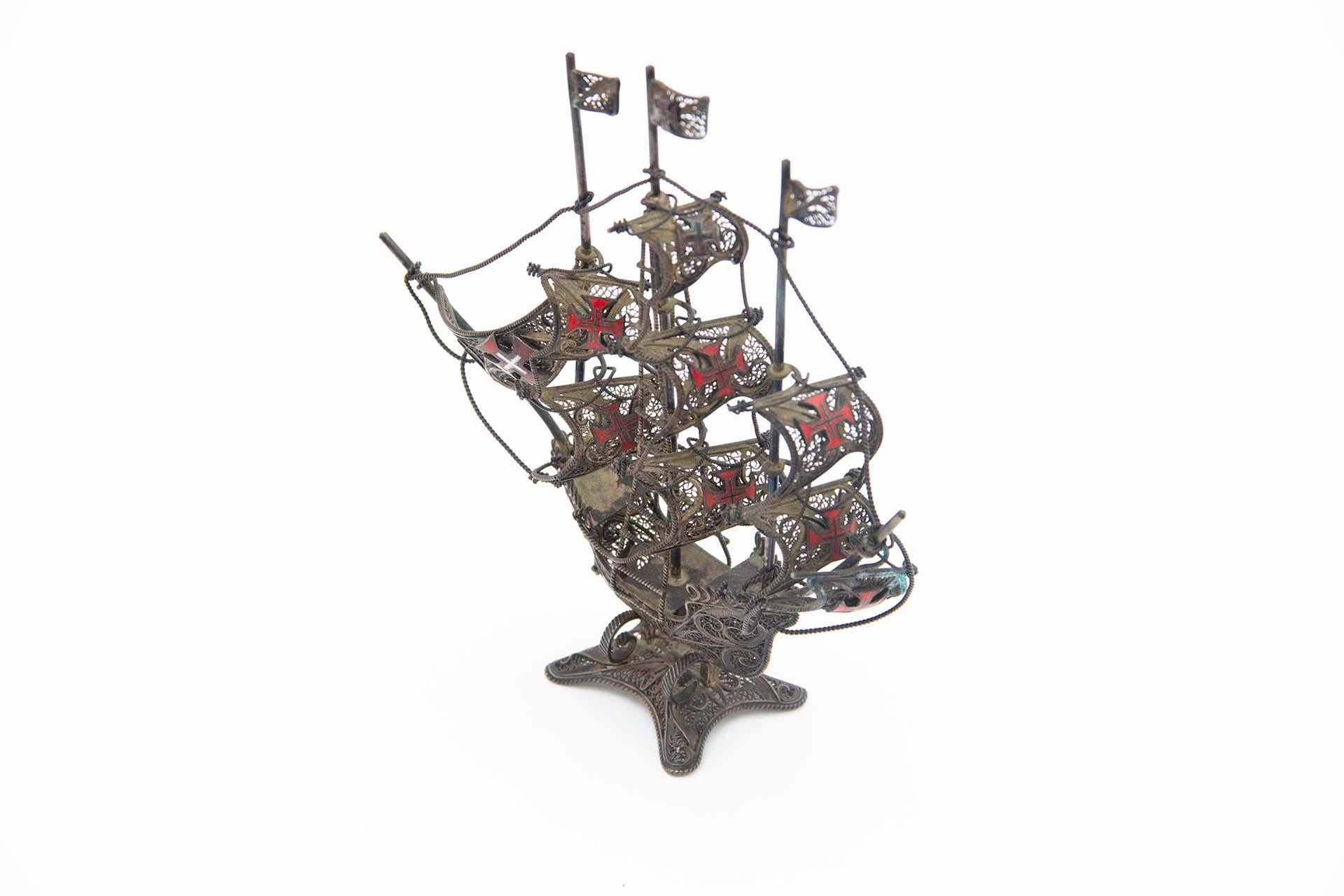 Description: Silver caravel with filigree mesh and crosses of the Order of Christ. Metal: Silver. Origin: Portuguese. Brand: Absent. Weight: 84.46 grams. Dimensions: 12.8cmx15cm. Content: 833/1000. Assay Mark: Absent. Additional information: Good