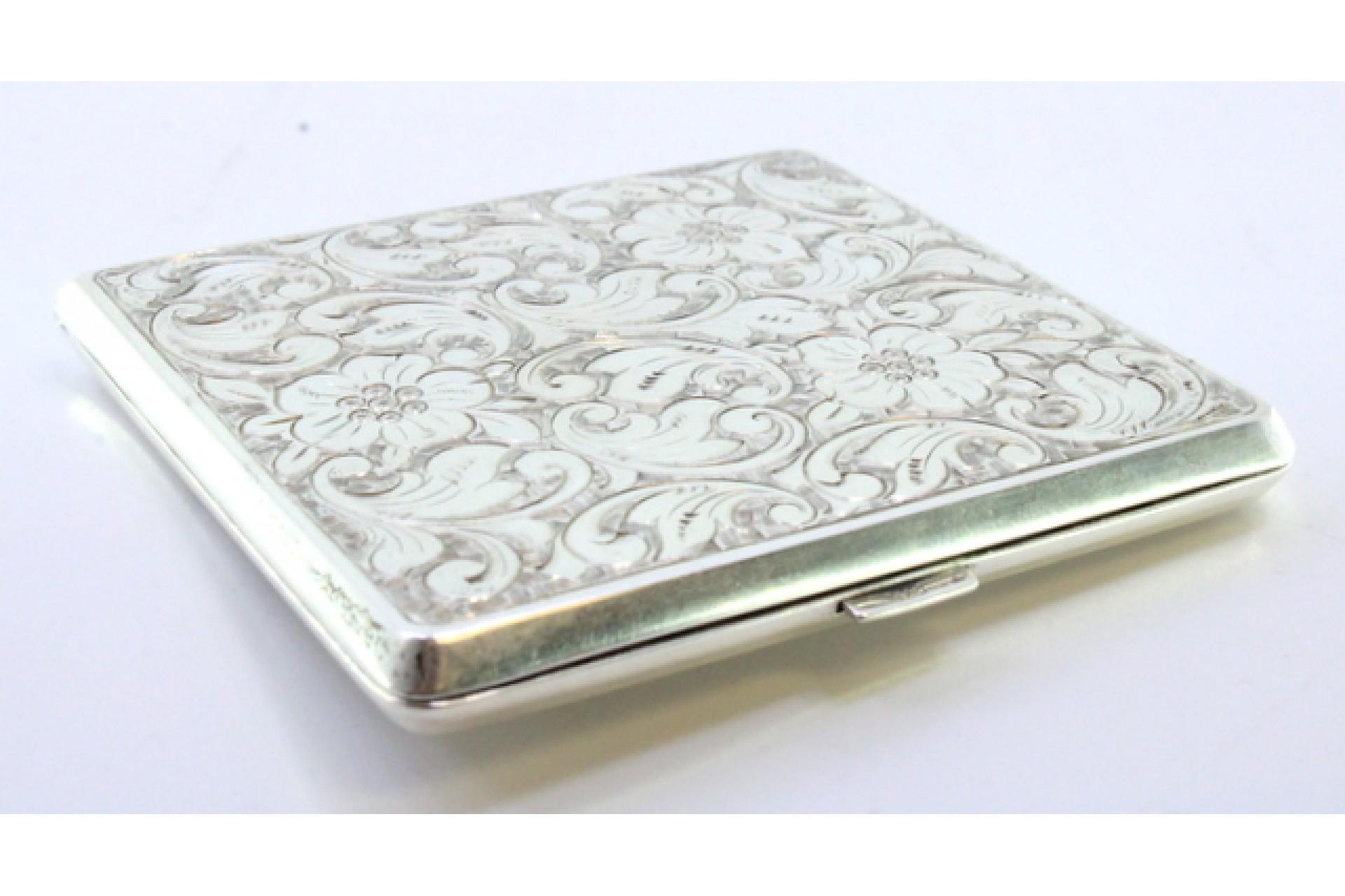 Description: Silver cardboard box with engraved floral motifs, high grooves on the back and spring-loaded hinged lid. Metal: Silver. Origin: European. Mark: Absent. Weight: 70.96 grams. Dimensions: 8cmx7.5cm. Content: 835/1000. Assay Mark: Absent.