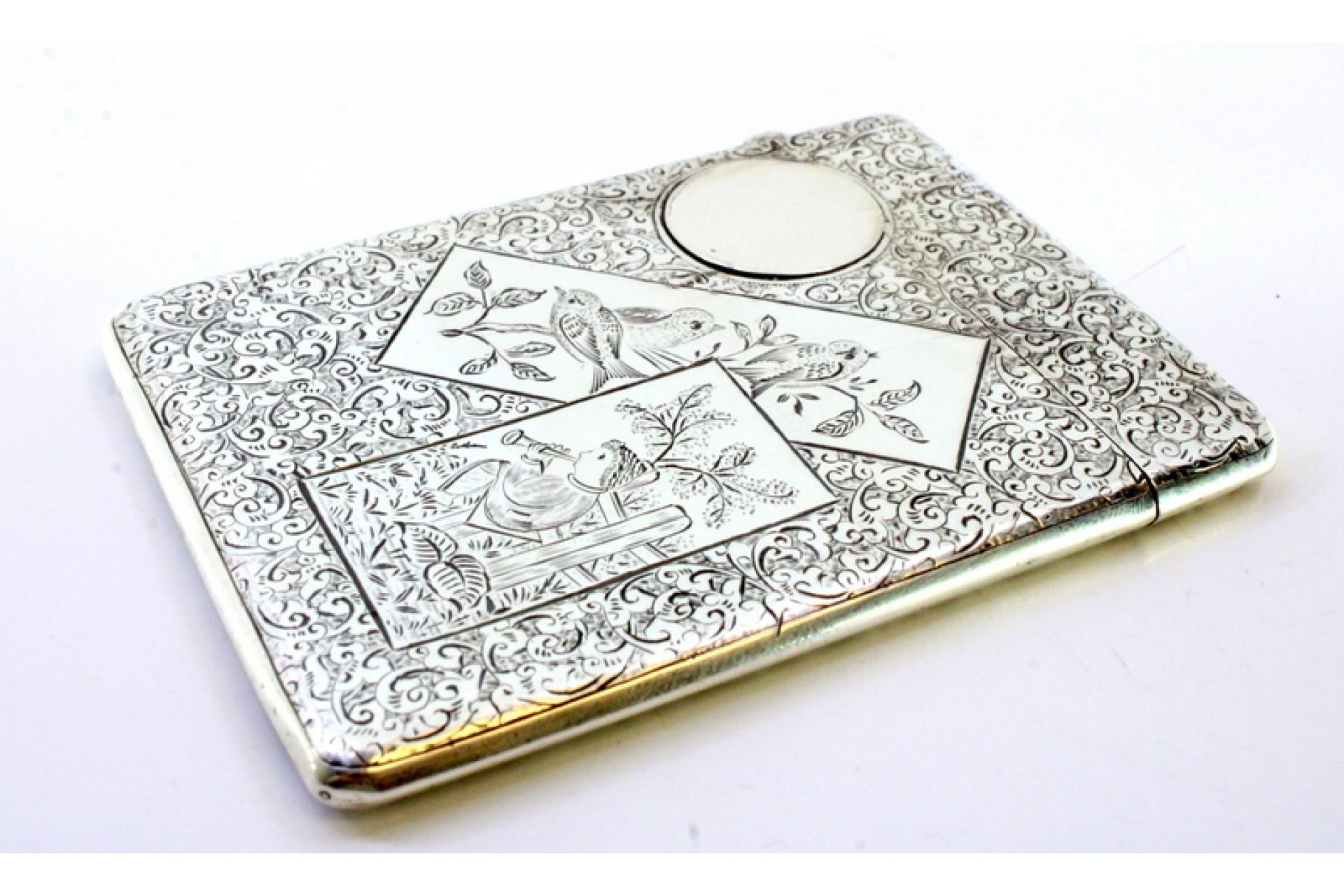 Description: Silver card case with engraved wreaths, birds and floral motifs surrounding a monogram card. Metal: Silver. Origin: English. Brand: Birmingham. Weight: 79.75 grams. Dimensions: 9.5cmx7cm. Content: 925/1000. Assay Mark: Yes, 1873 by