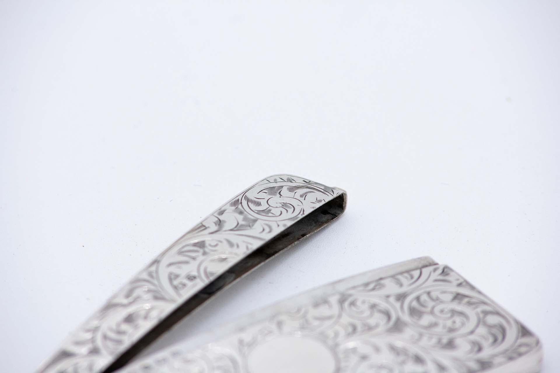 Description: Silver card case with engraved wreaths surrounding a curved monogram card. Metal: Silver. Origin: English. Brand: Birmingham. Weight: 45.66 grams. Dimensions: 9cm x 0.5cm. Content: 925/1000. Assay Mark: Yes, 1935 by Henry Matthews.