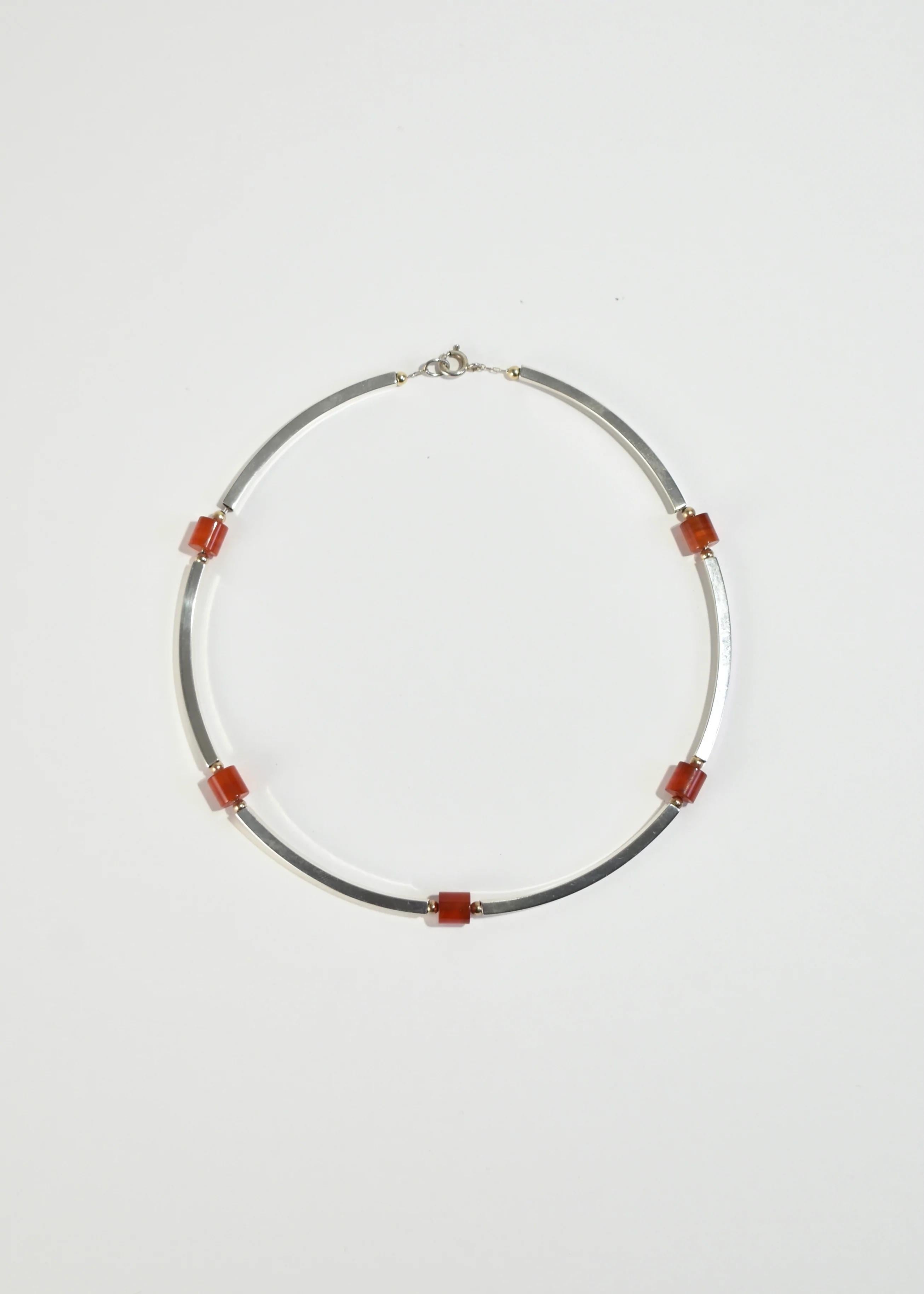 Stunning vintage collar necklace with hollow rectangle detail and polished carnelian beads, clasp closure. Stamped Sterling.

Material: Sterling silver, carnelian.