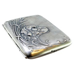 Silver case with Art Nouveau dog relief among reeds and hinged lid