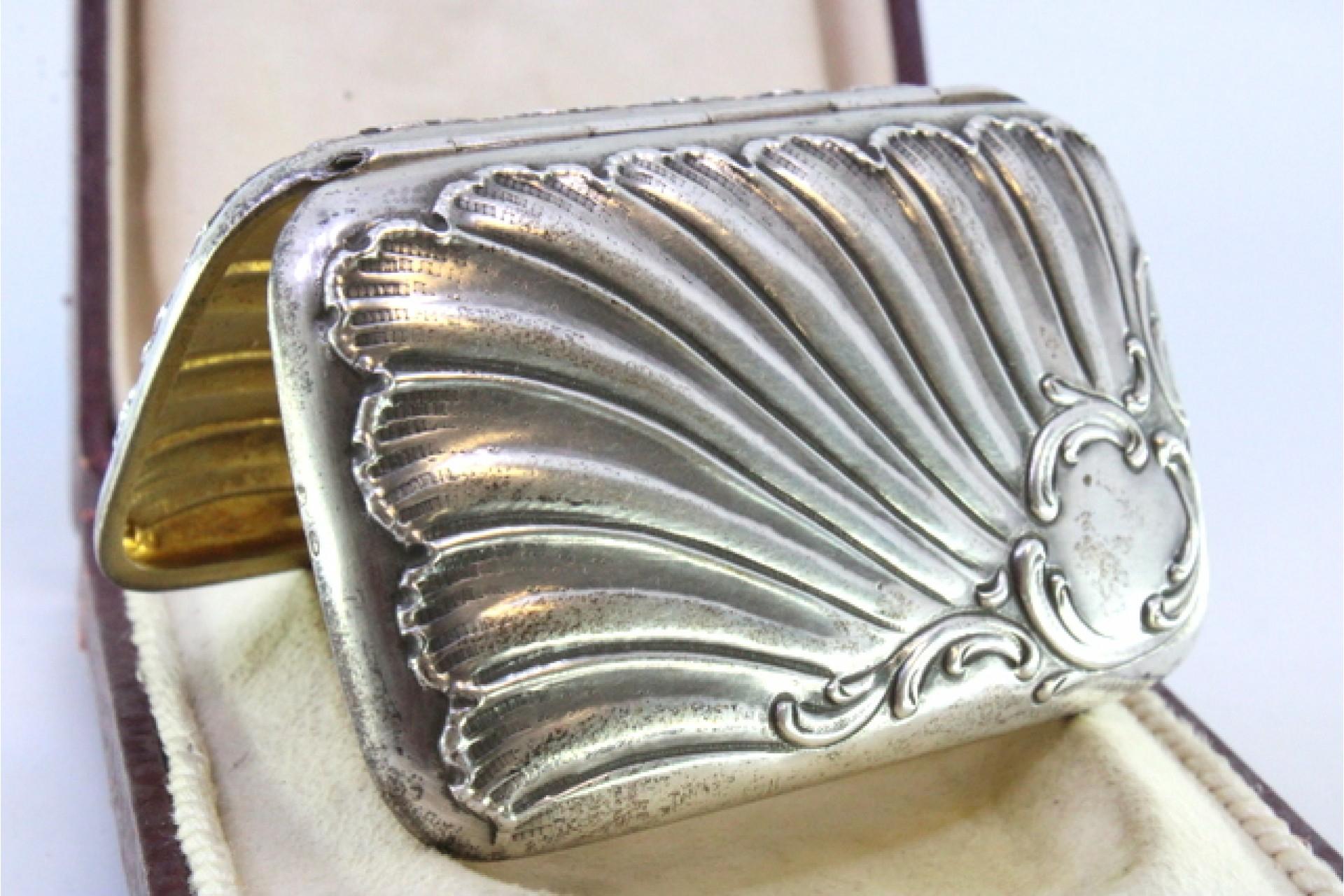 Description: Silver cigarette case with Art Nouveau reliefs surrounding a monogram card and gold interior. Metal: Silver. Origin: Portuguese. Brand: Javali II. Title. Weight: 56.86 grams. Dimensions: 7.7cm x 5cm. Content: 833/1000. Assay Mark: Yes,