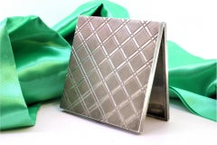 Silver case with checkered reliefs, hinged lid and ruby clasp