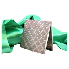 Silver case with checkered reliefs, hinged lid and ruby clasp