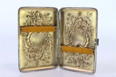 Silbernes Etui mit geprägten Blumen um das Monogramm und Scharnierdeckel