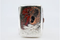 Silbernes Gehäuse mit eingravierten Zweigen um das Monogramm und Scharnierdeckel