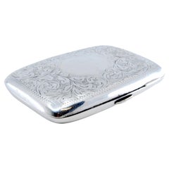 Silver case with engraved branches around monogram and hinged lid