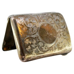 Silver case with engraved garlands around curved monogram and gold interior