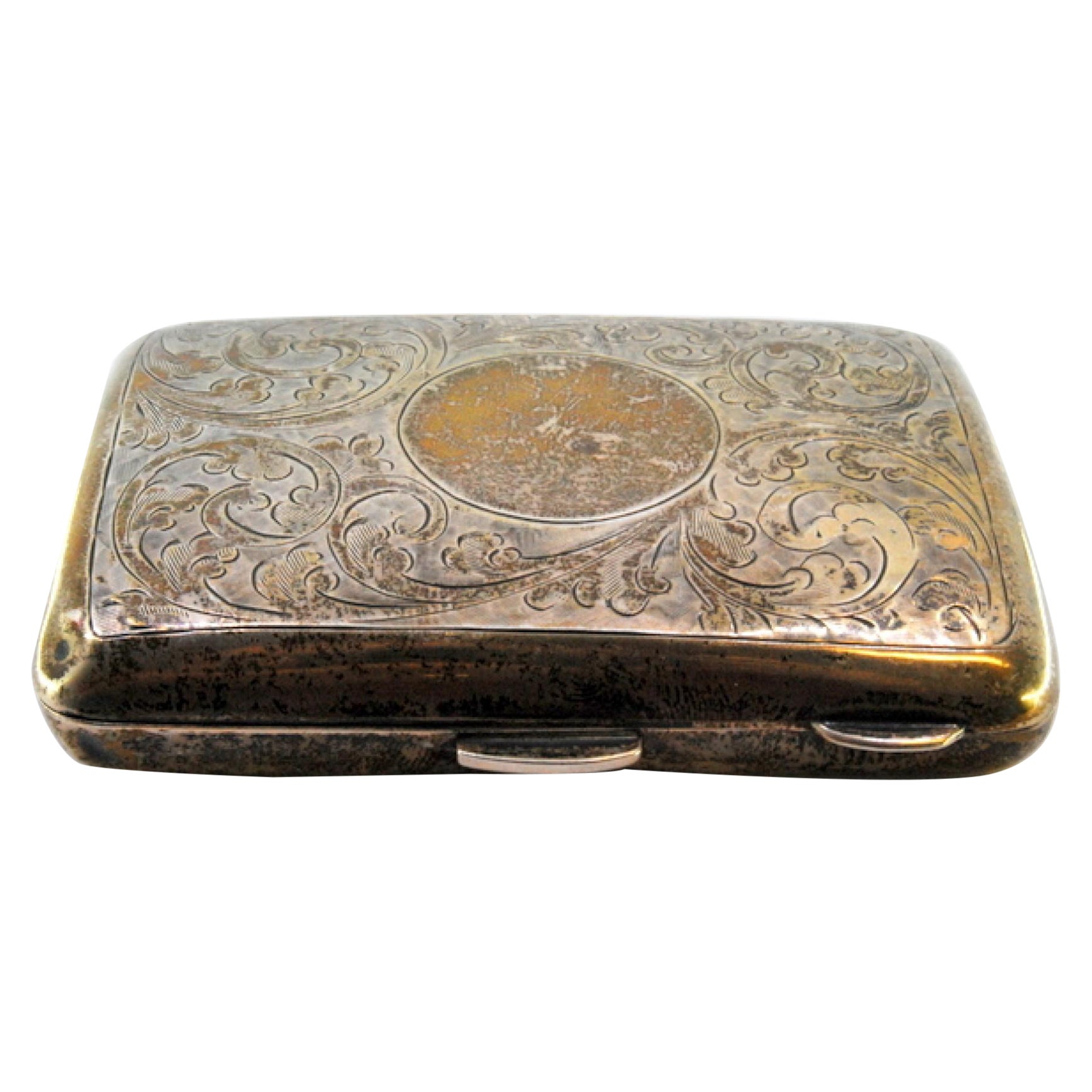 Silver case with engraved garlands around curved monogram and gold interior