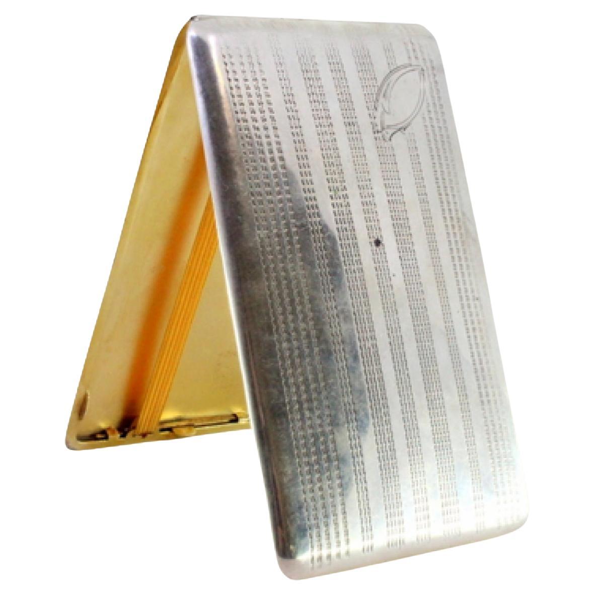 Silver case with engraved lengthwise bands, monogram and gold interior