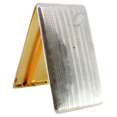 Silver case with engraved lengthwise bands, monogram and gold interior