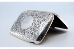 Silbernes Gehäuse mit floralen Gravuren um ein geschwungenes Monogramm und Scharnierdeckel