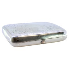 Silver case with floral engravings, curved monogram and spring-hinged lids
