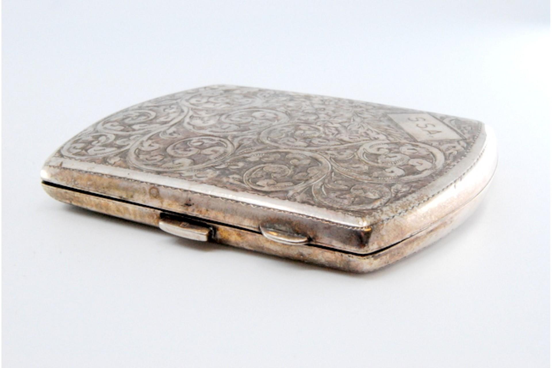 Description: Silver cigarette case with floral motifs engraved on both sides, including a monogram card and a hinged lid. Metal: Silver. Origin: English. Brand: JR Weight: 78.04 grams. Dimensions: 6.4x1cm. Content: 925/1000. Assay Mark: Yes, since