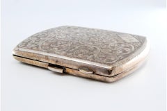 Silver case with floral engravings, monogram and hinged lid