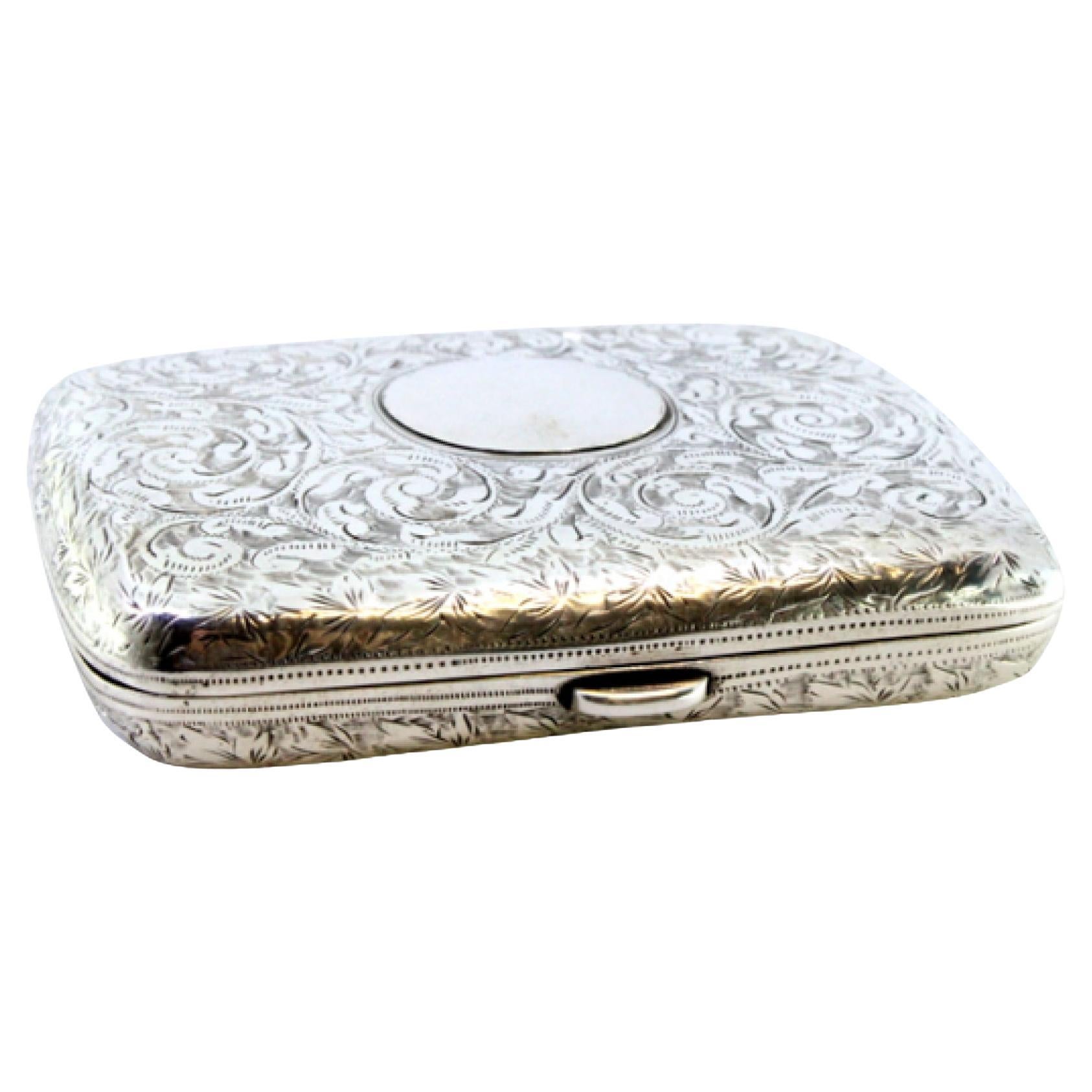 Silver case with floral engravings, monogram card and hinged lid
