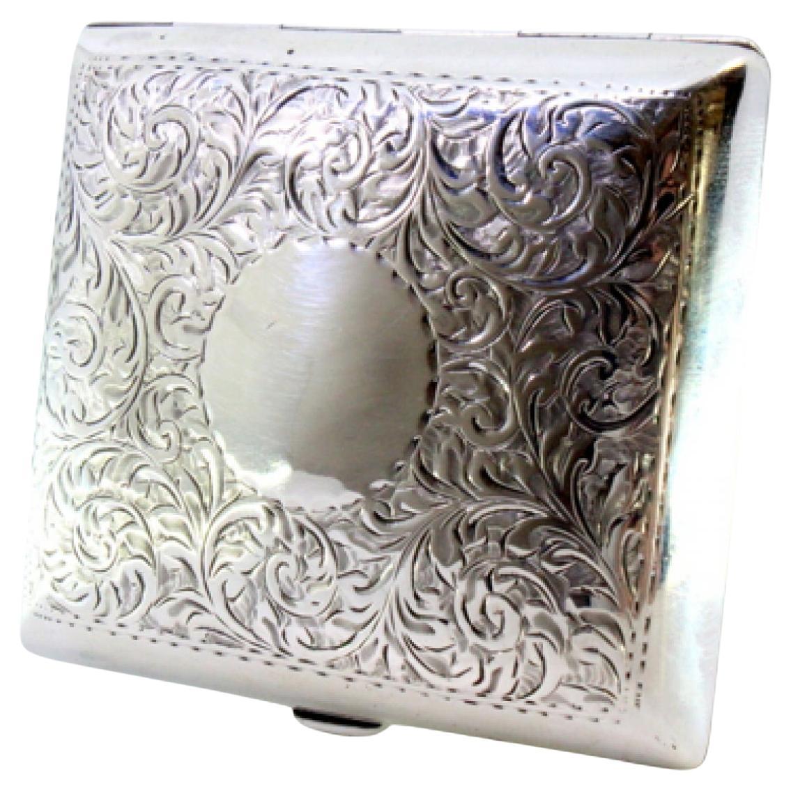 Silver case with floral reliefs, garlands and curved monogram, gold interior