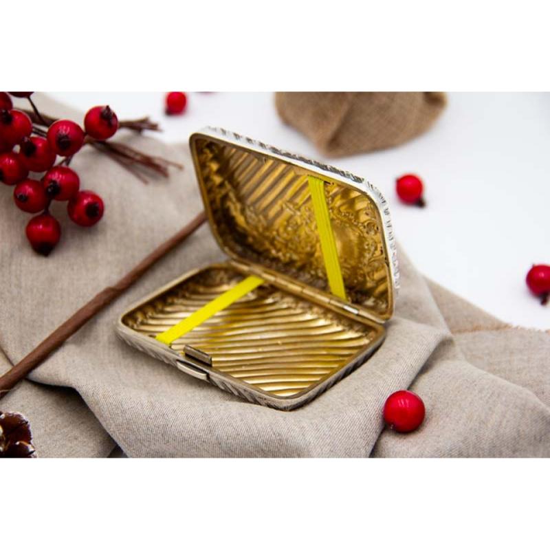 Description: Silver cigarette case with fluted reliefs, floral motifs and raised garlands surrounding a monogram card. Metal: Silver. Origin: French. Brand: Boar's Head. Weight: 74.37 grams. Dimensions: 8.5cmx1.2cm. Content: 800/1000. Assay Mark: