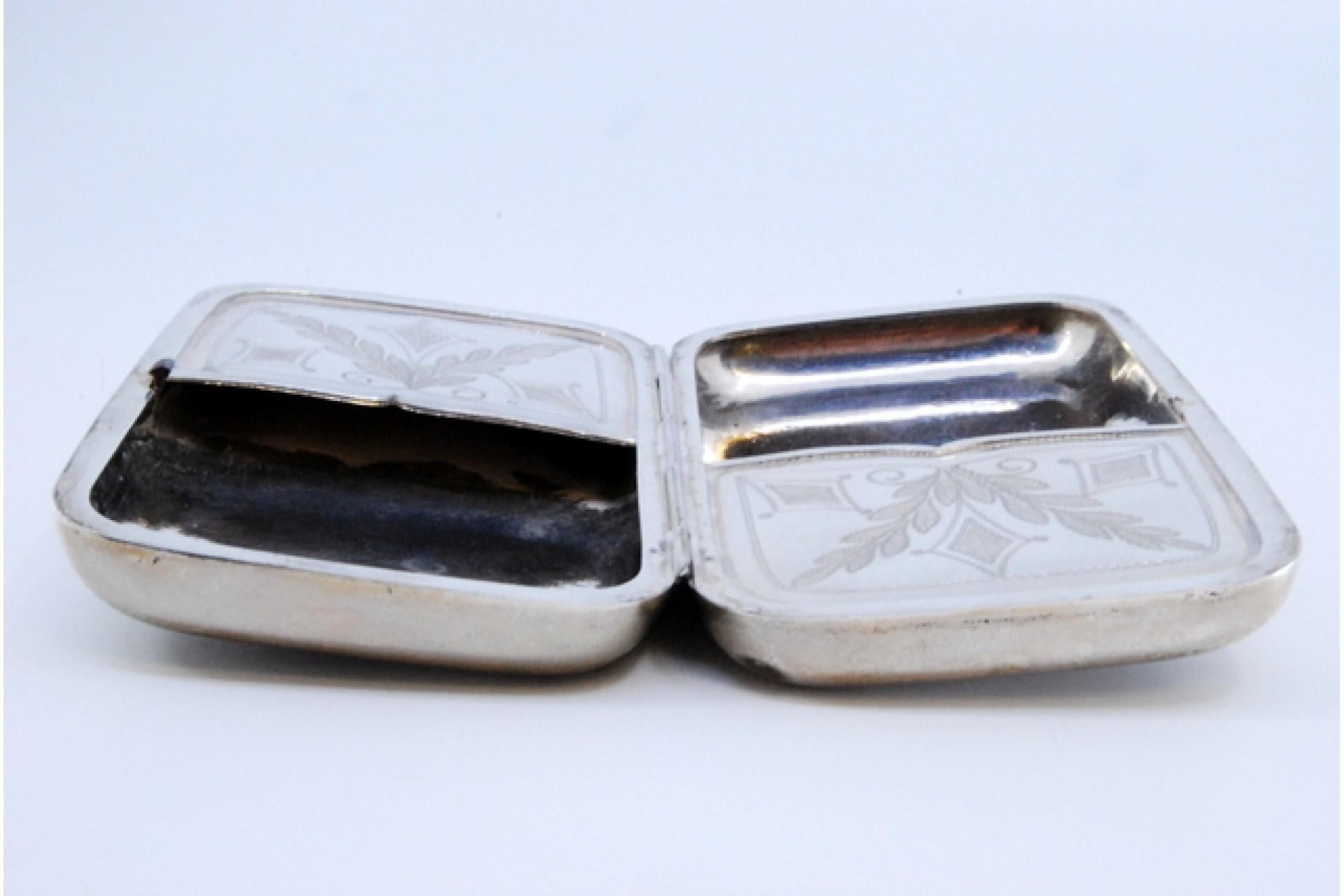 Description: Silver cigarette case with engraved wreaths on the hinged lid and interior with two compartments. Metal: Silver. Origin: European. Mark: Absent. Weight: 150.26 grams. Dimensions: 11x7cm. Content: 835/1000. Assay Mark: Absent. Additional