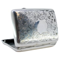 Silver case with garlands around curved monogram and silver interior