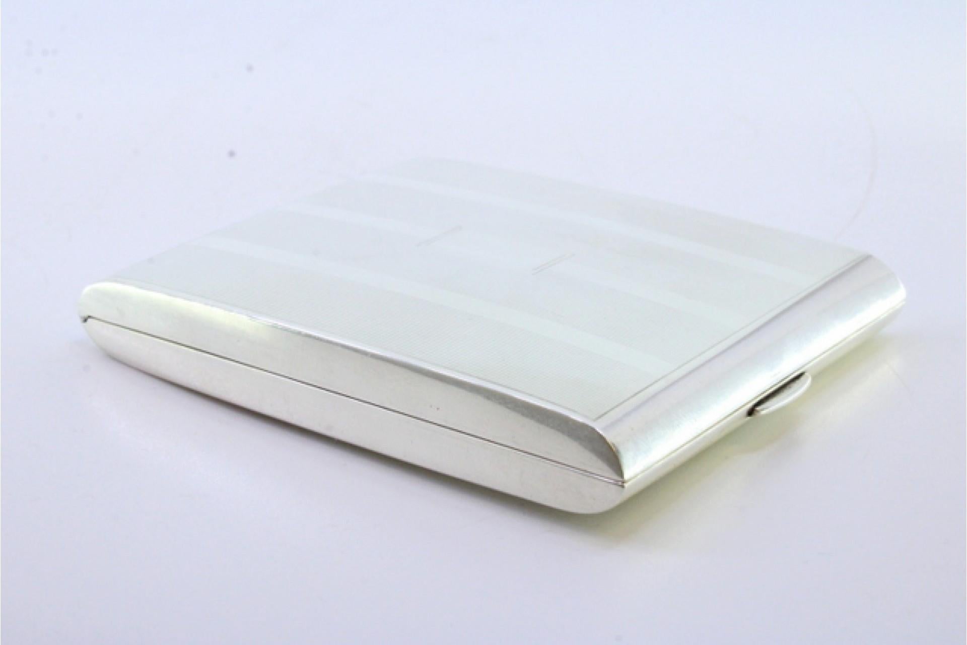 Description: Silver cigarette case with guilloche bands along the length and a double cigarette holder inside in gold. Metal: Silver. Origin: American. Brand: Unknown. Weight: 119.82 grams. Dimensions: 9.5cm x 7.5cm. Content: 925/1000. Assay Mark: