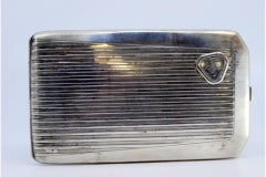 Silver case with lengthwise bands, monogram and gold interior