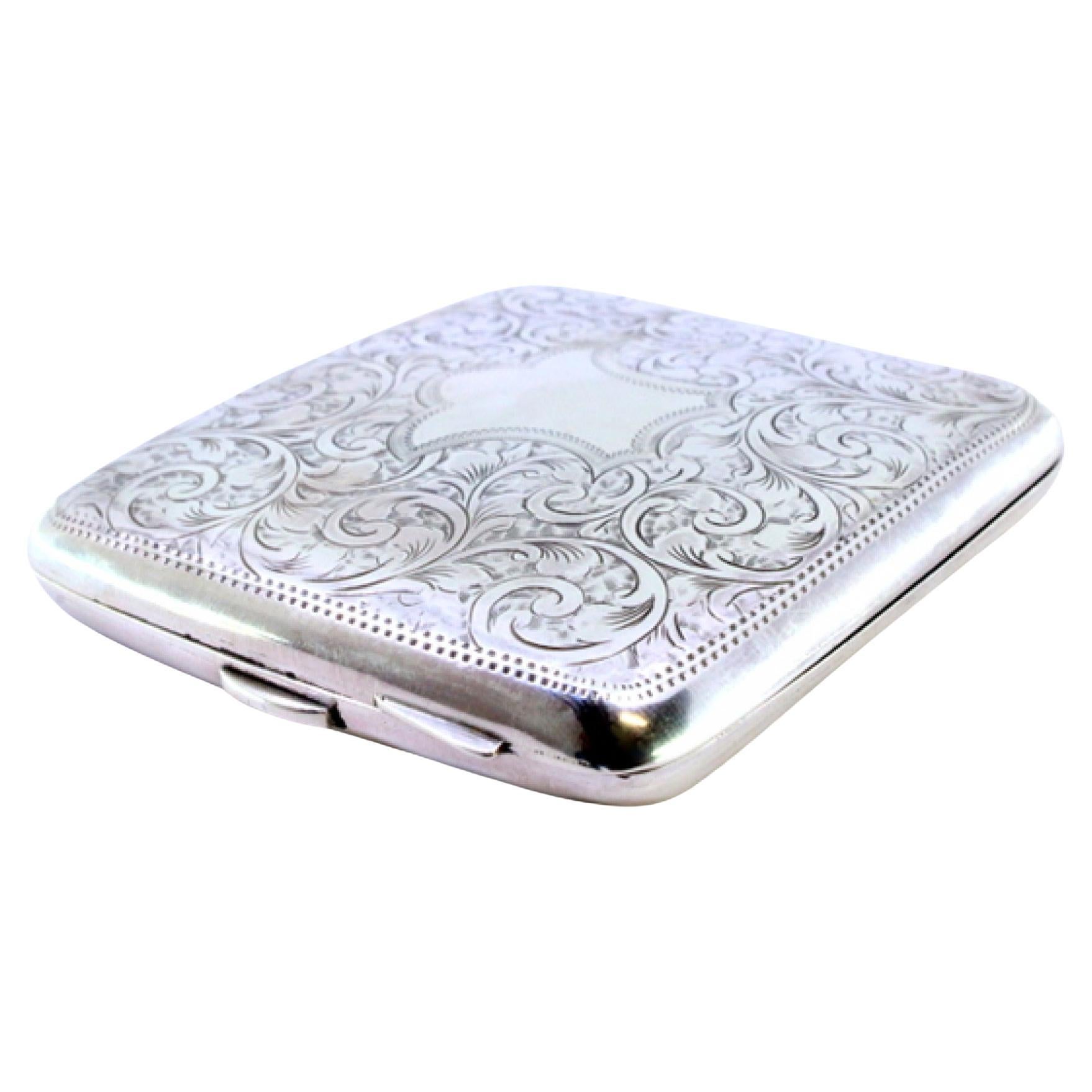Silver case with plant engravings around curved monogram card