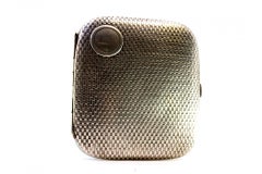 Silver case with recessed reliefs around monogram and gold interior