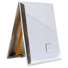 Silver case with surface engravings around monogram and gold interior