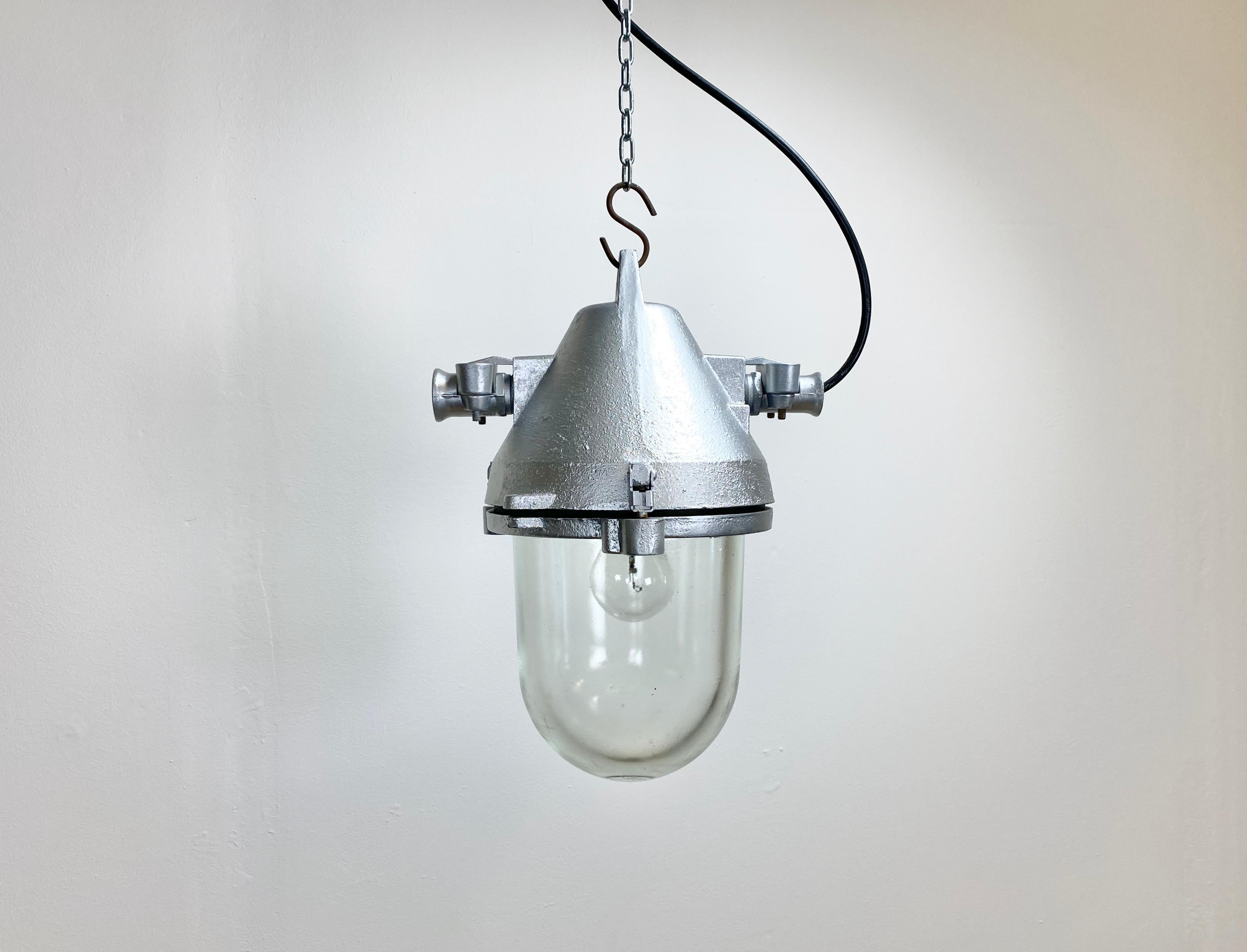 Silver industrial lamp with massive protective glass bulb. Made by Elektrosvit in former Czechoslovakia during the 1960s.It features silver cast aluminium body and clear glass. Porcelain socket for E27 lightbulbs. Newly wired. Weight: 5.5 kg.