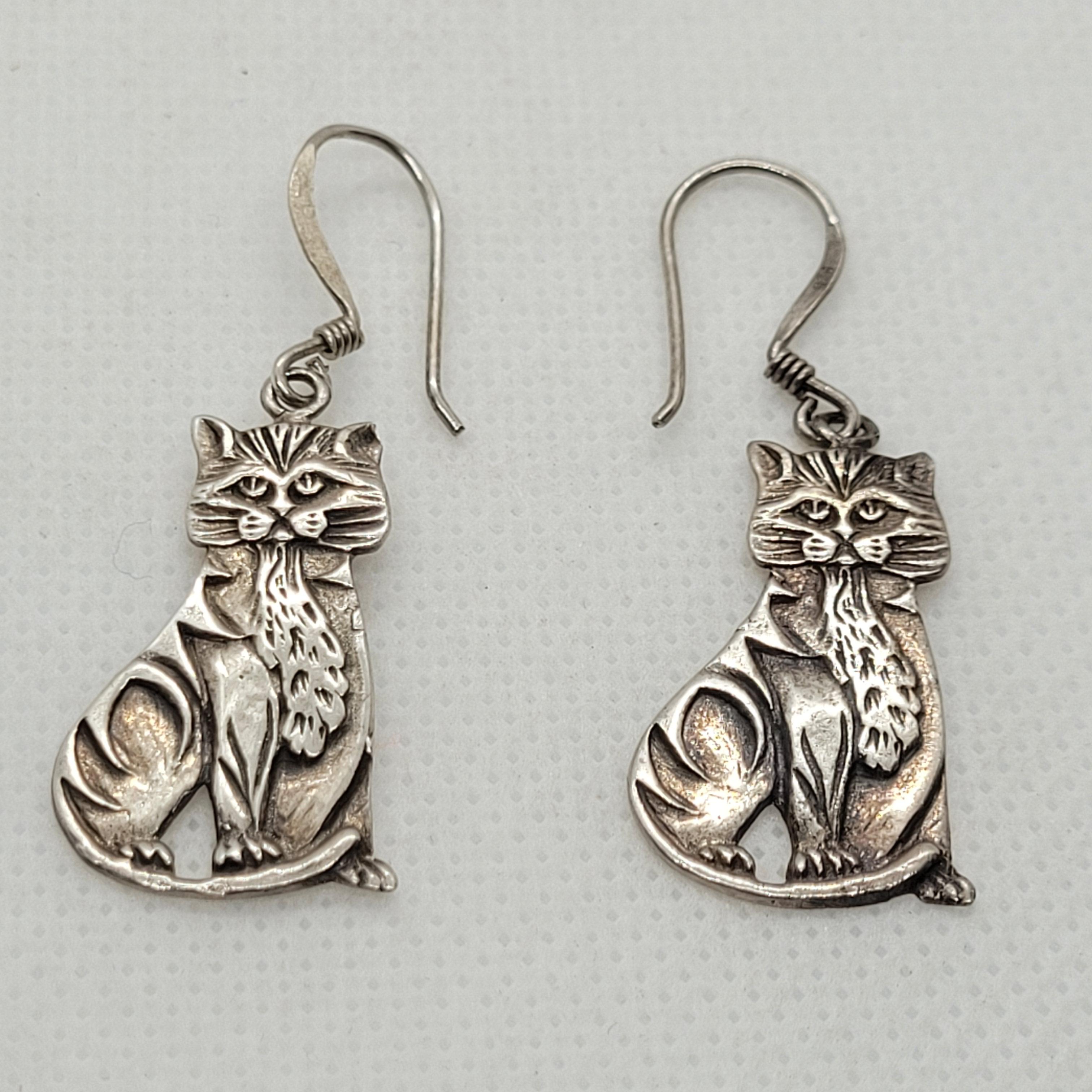 These stunning Silver Cat Hook Earrings are a must-have for any feline enthusiast! Expertly crafted with a stamped 925 mark, they offer a total length of 25mm and a width of 10-15mm, making them the perfect size for everyday wear. Weighing in at 4.5