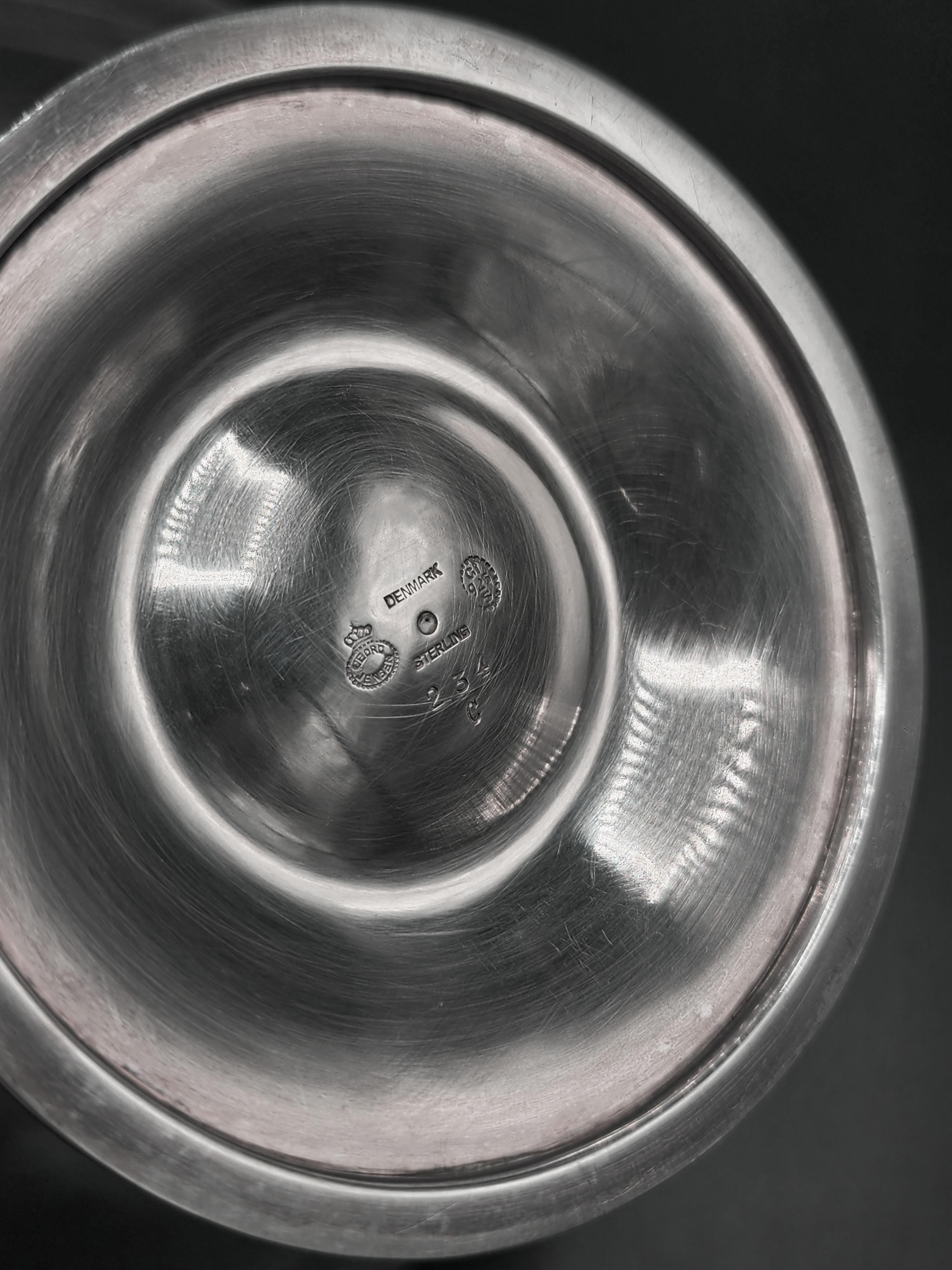Dänischer Art Deco Georg Jensen Silber Tafelaufsatz Modell 234 C
Schöner silberner Tafelaufsatz von Georg Jensen im Art-Déco-Stil mit einem Sockel, der von einem verschnörkelten Ständer mit geschnitzten Figuren und dekorativen Elementen getragen