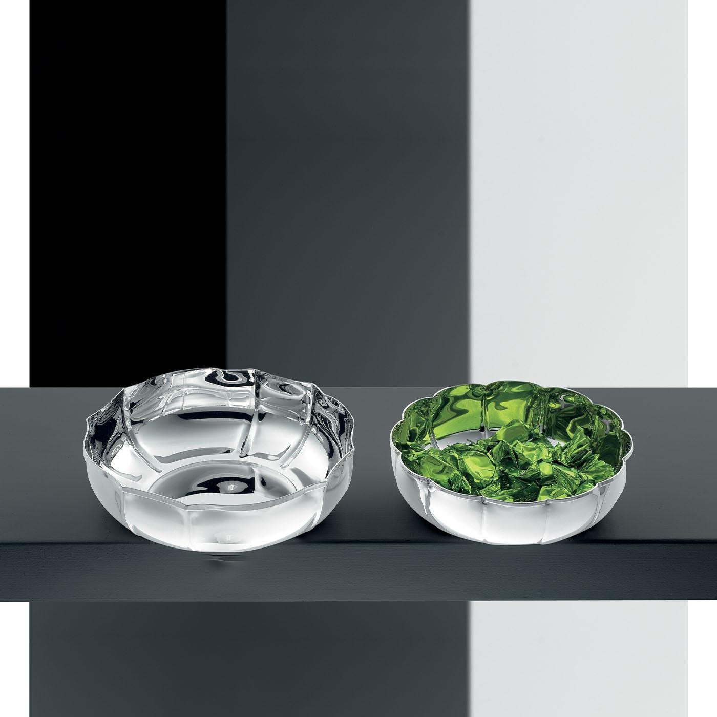 This splendid centerpiece bowl is a refined design whose silhouette is distinguished by inner grooves that result in slight protuberances for a truly precious textural quality. The luminosity owed to the gleaming silver plating is emphasized in its
