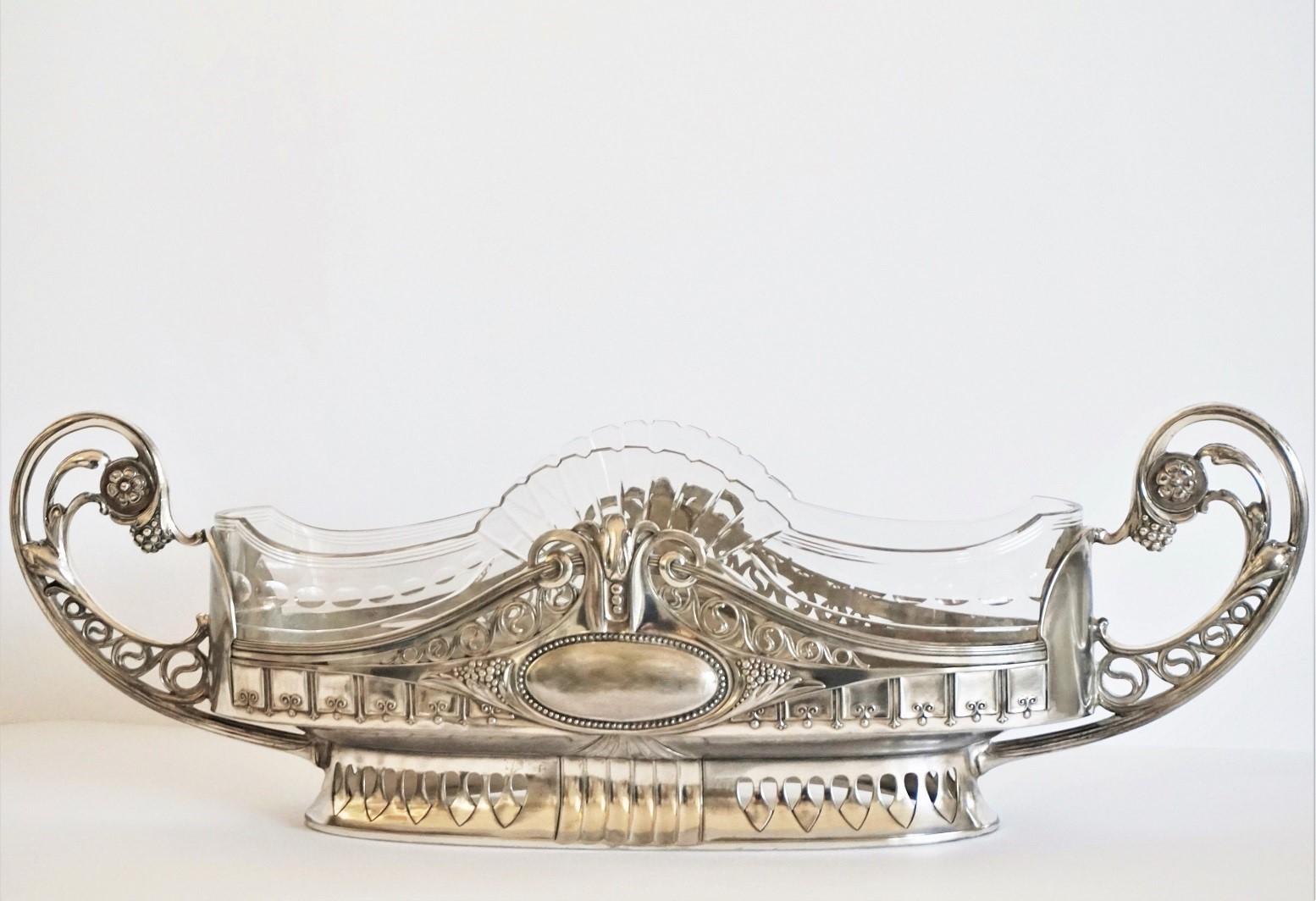 Gran centro de mesa/jardinera de plata de época Art Nouveau con forro original de cristal tallado, Austria, 1900-1910. Este maravilloso y exclusivo centro de mesa tiene forma ovalada con elaborados detalles hechos a mano. El cuenco de cristal está