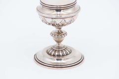 Silver chalice with a smooth body and relief on the base