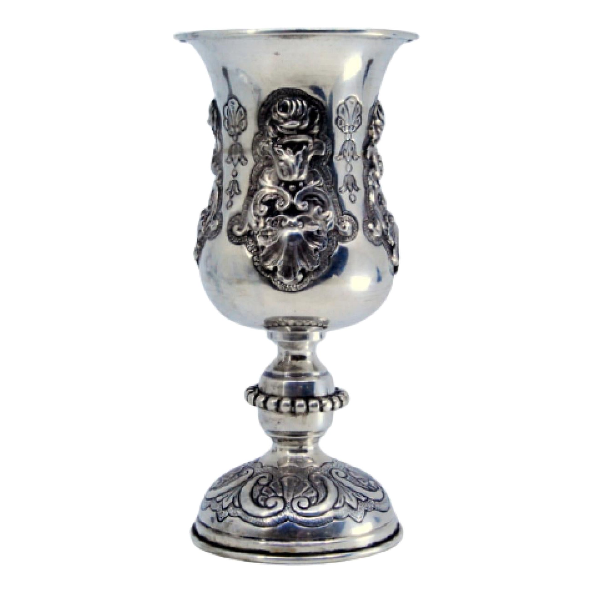 Silver chalice with floral motifs and shells in relief, set on a circular base