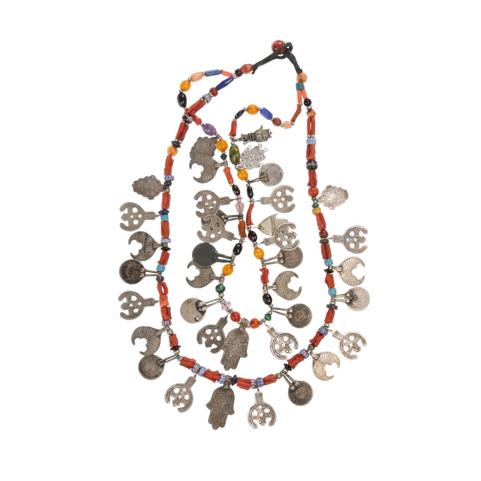 Un collier fait sur mesure par le célèbre bijoutier marocain Chez Faouzi de Marrakech. Un collier à double brin composé de perles de cornaline anciennes et de breloques en argent marocain ancien travaillées à la main, avec la breloque dorsale de