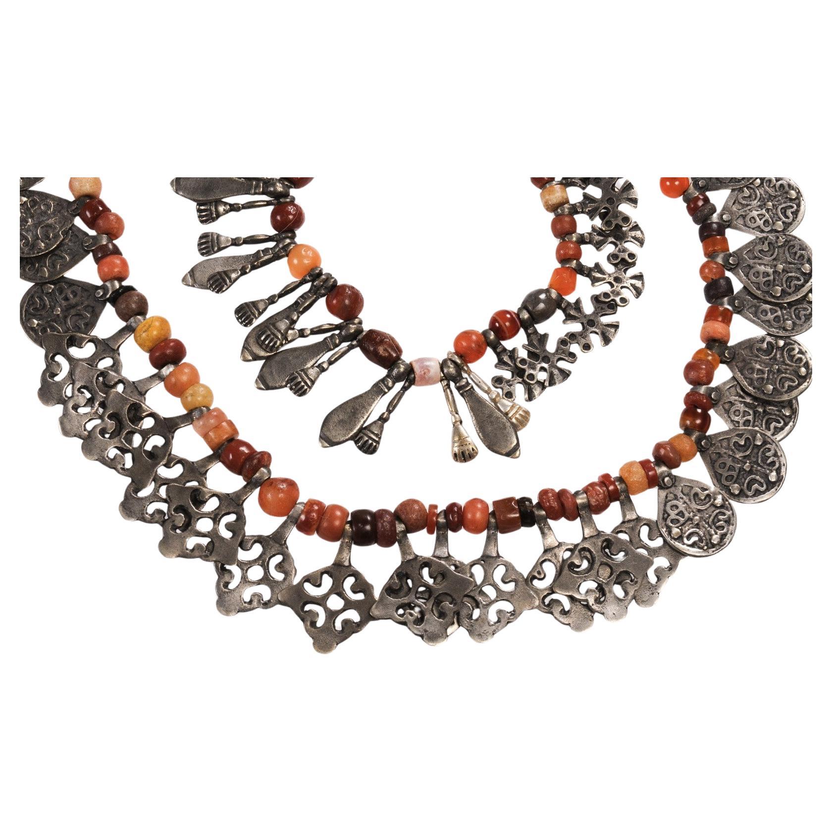 A Custom Made Necklace by Famous Moroccan Jeweler Chez Faouzi of Marrakech. A Double Stranded Necklace made up of Antique Carnelian Beads and Hand Tooled Antique Moroccan Silver Accent Charms with the Signature Faouzi Back Neck Charm. The black