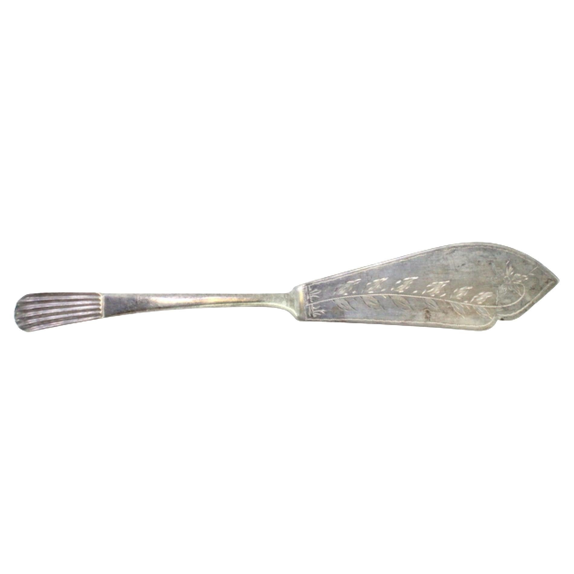 Silver cheese knife with floral engravings and reed-style embossed handle