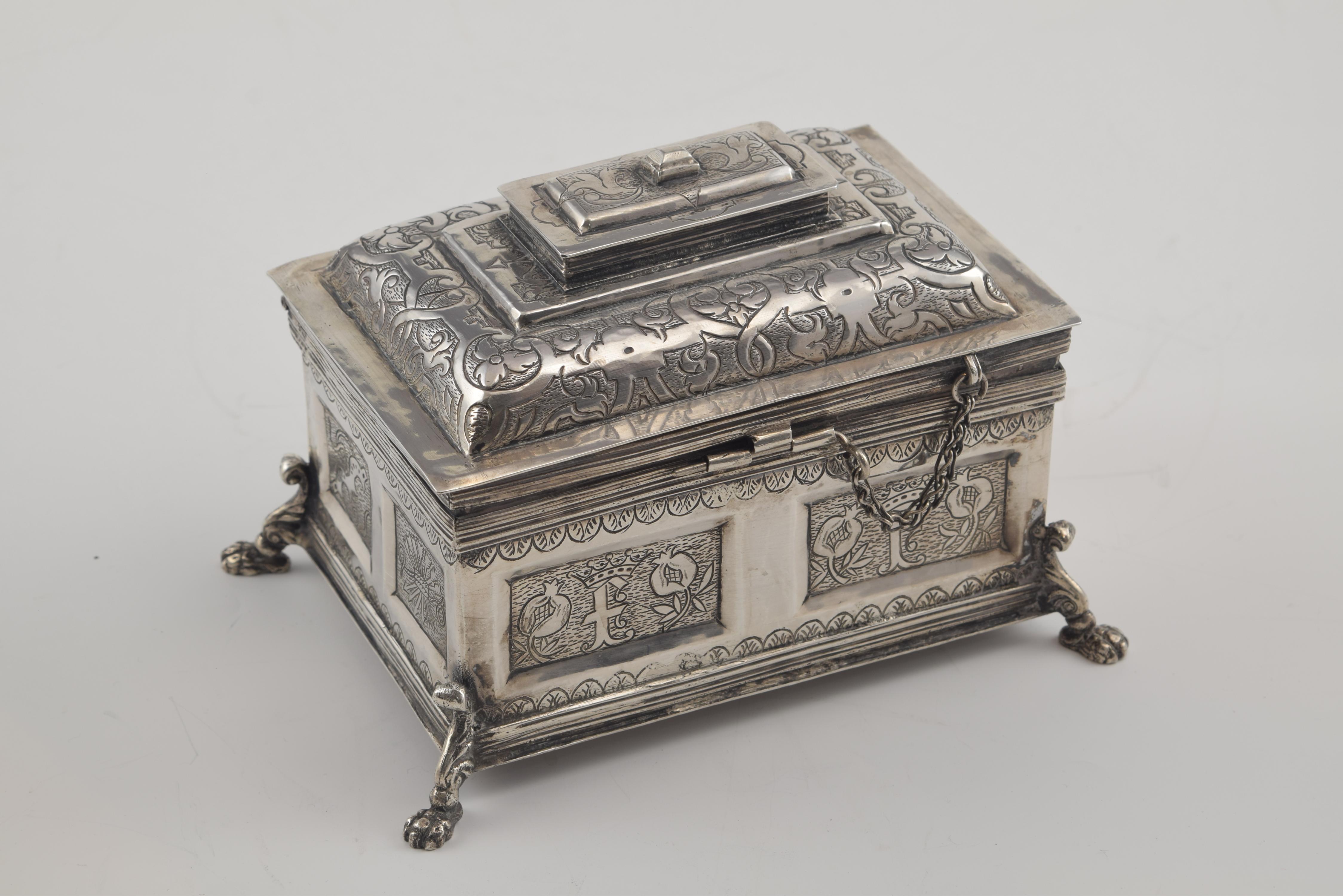 Arquette inspiré par des modèles du 17ème siècle. Argent, Espagne, 20e siècle
Coffret rectangulaire en argent de couleur, avec quatre pieds dans les angles en forme de rouleau et terminés en griffe, orné sur les façades d'un décor de moulures, de