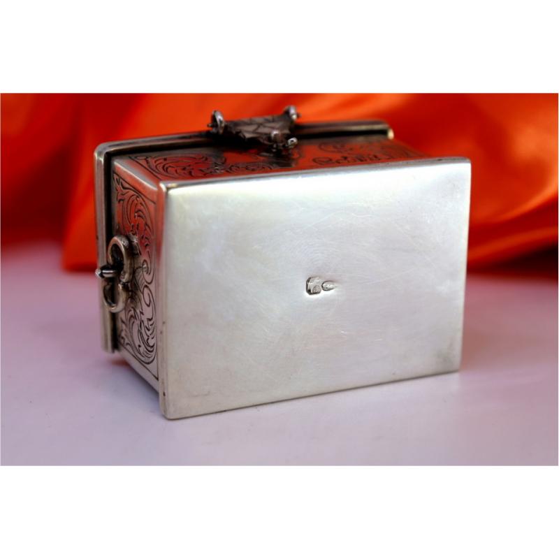 Description: Silver box in the shape of a chest with engravings, shells with two handles and hinged lid with clasp. Metal: Silver. Origin: Portuguese. Mark: standing eagle. Weight: 87.88 grams. Dimensions: 5.5cmx4cm. Content: 833/1000. Assay Mark: