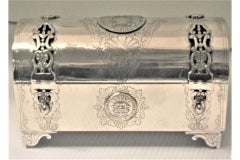 Silver chest-shaped jewelry box inlaid with monarchy coins and hinged lid