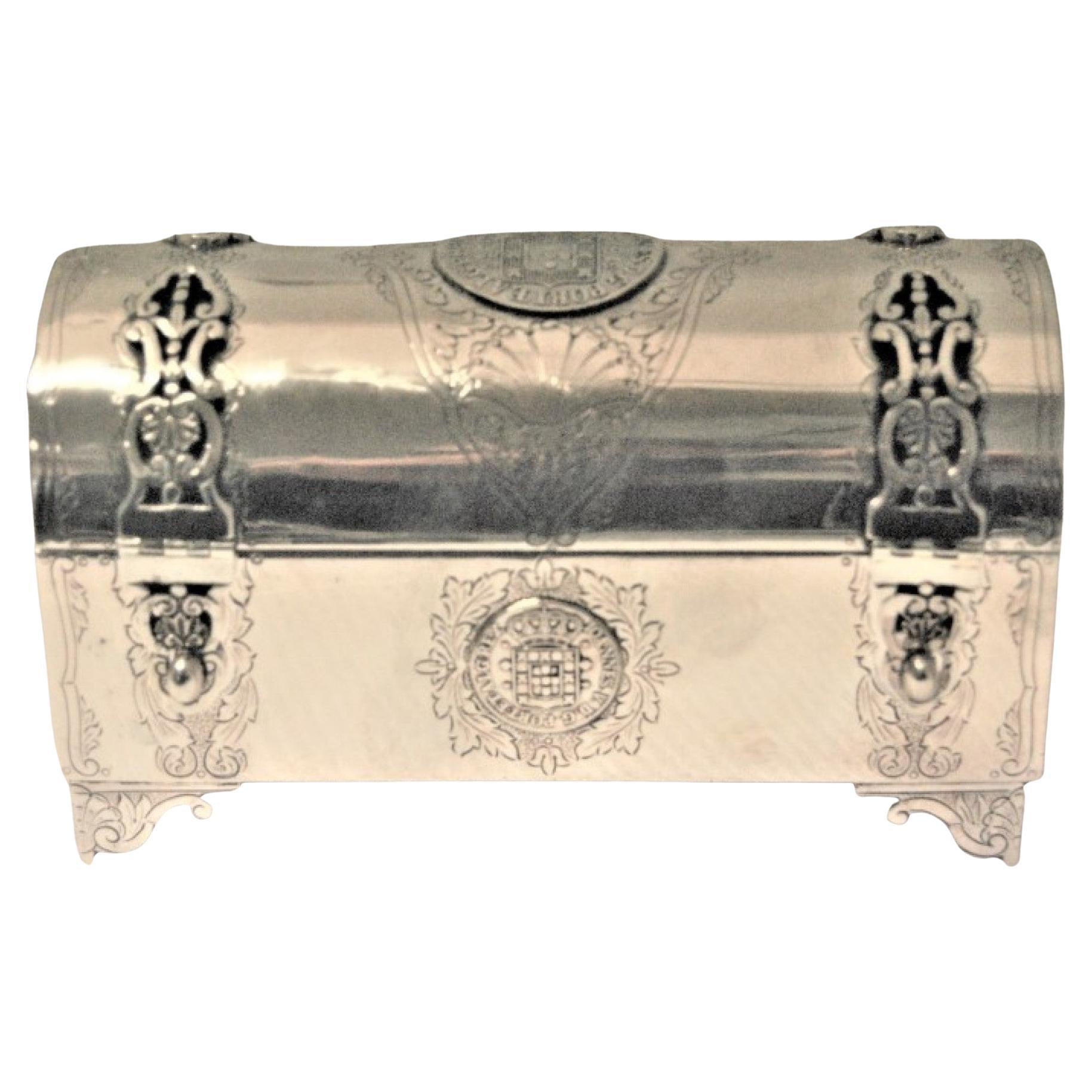 Silver chest-shaped jewelry box inlaid with monarchy coins and hinged lid