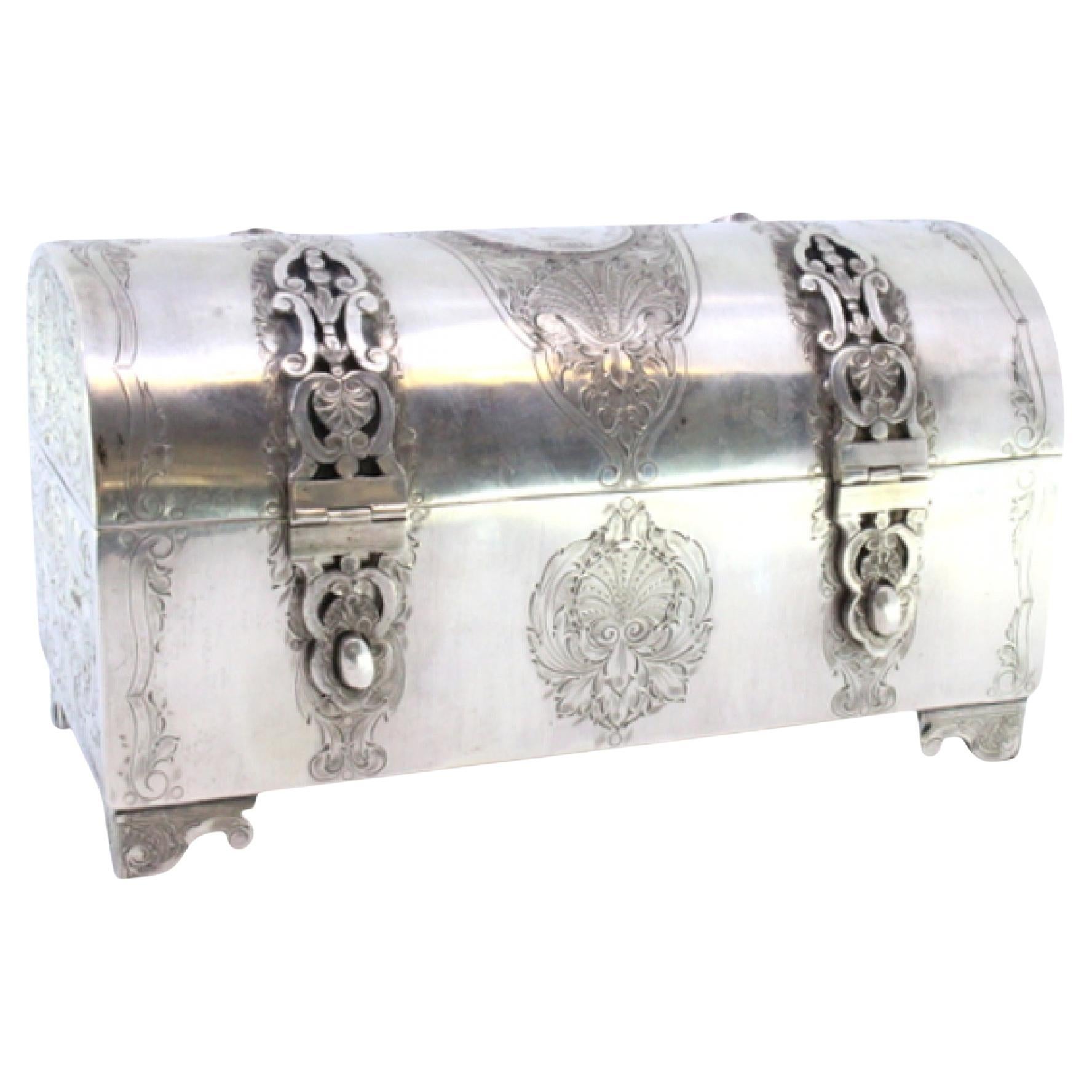 Silver chest-shaped jewelry box with coin appliqué and red velvet interior