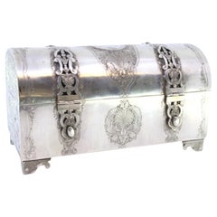 Silver chest-shaped jewelry box with coin appliqué and red velvet interior