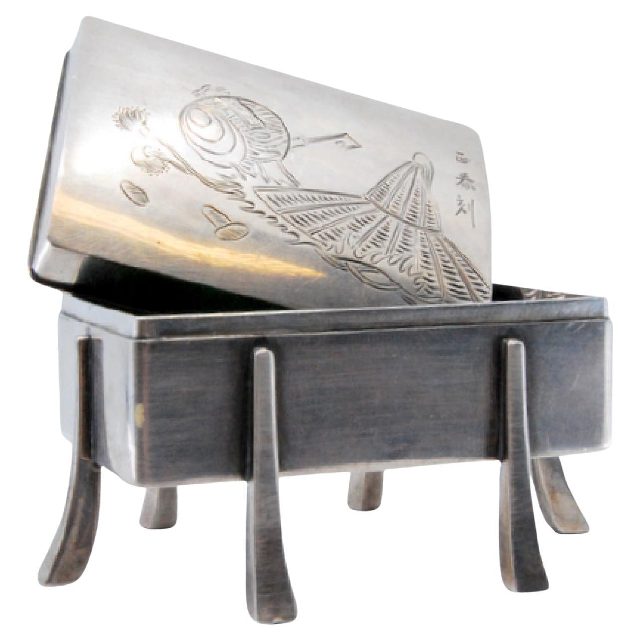 Silver chest-shaped jewelry box with oriental lid engraving on raised feet For Sale