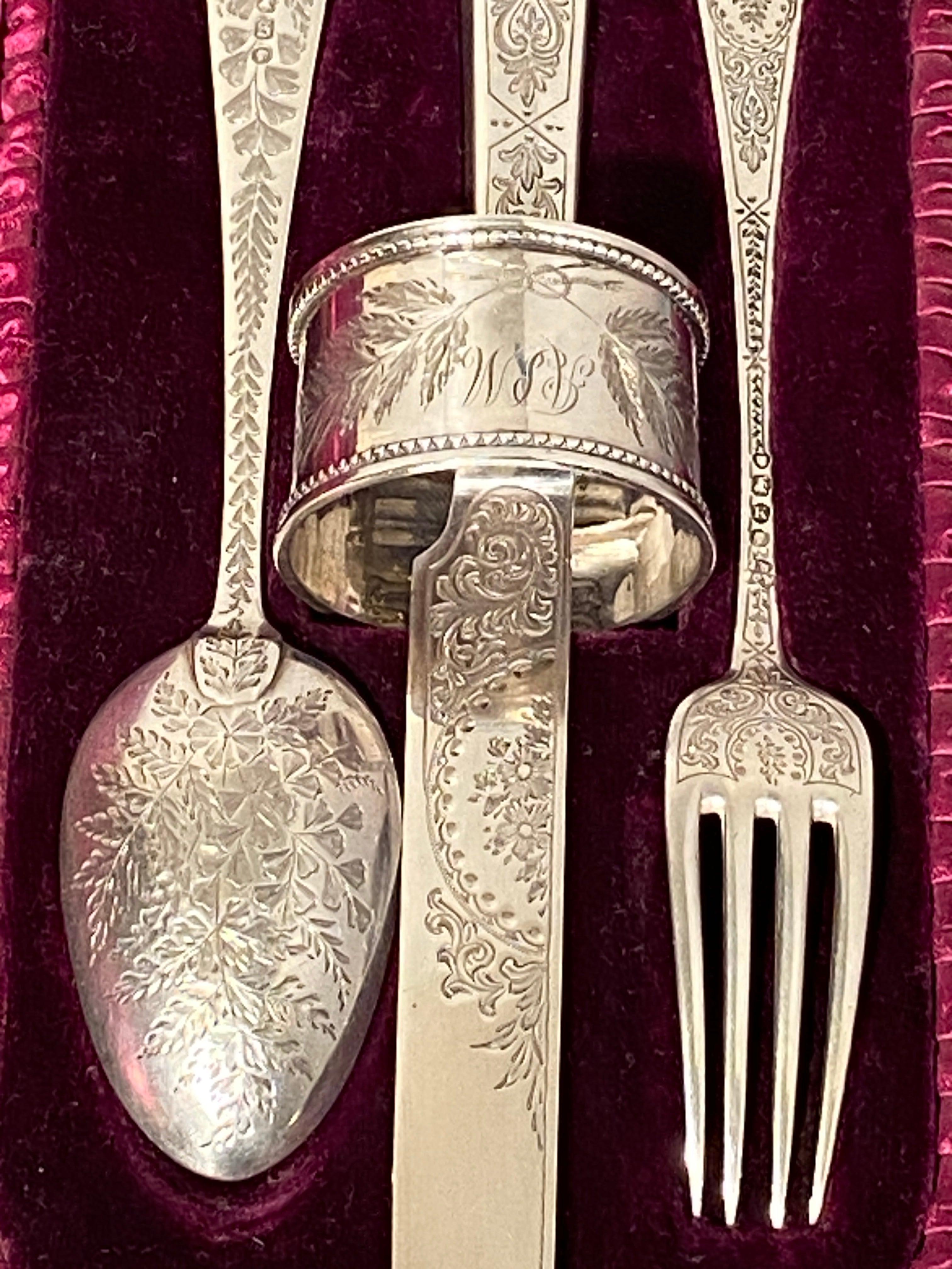Silver Christening Set Edward Barnard & Sons Engraved ASM
A silver christening set consisting of spoon 1873 and napkin ring 1875 of one design and a fork 1885 and knife 1886 of another design. 
All assayed in London and boxed by Drummonds of