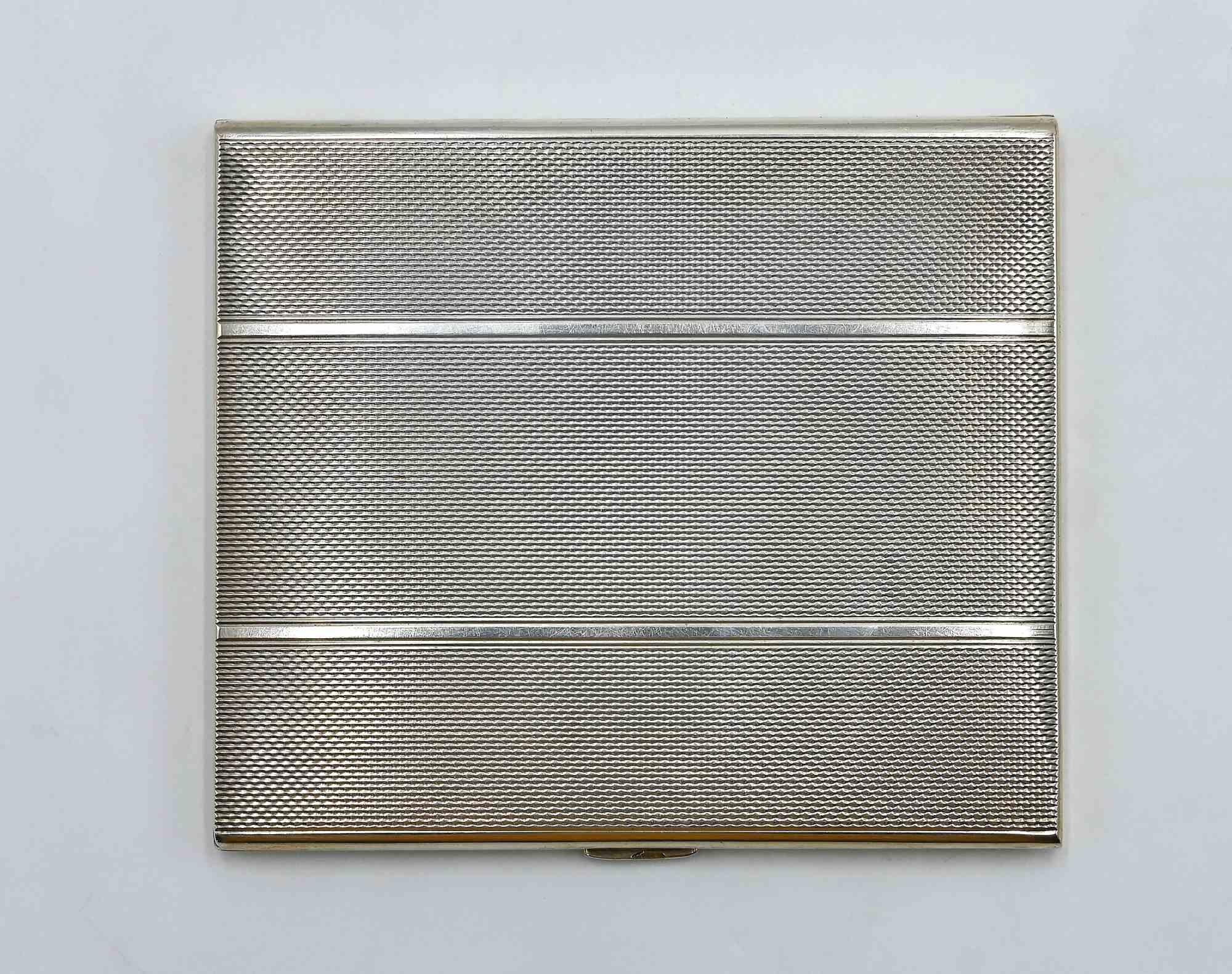 Raffinato portasigarette realizzato in argento 800, questo pezzo esemplifica il design continentale dei primi anni del XX secolo con il suo elegante profilo rettangolare e la sottile decorazione guilloché su entrambi i lati. L'astuccio si apre per